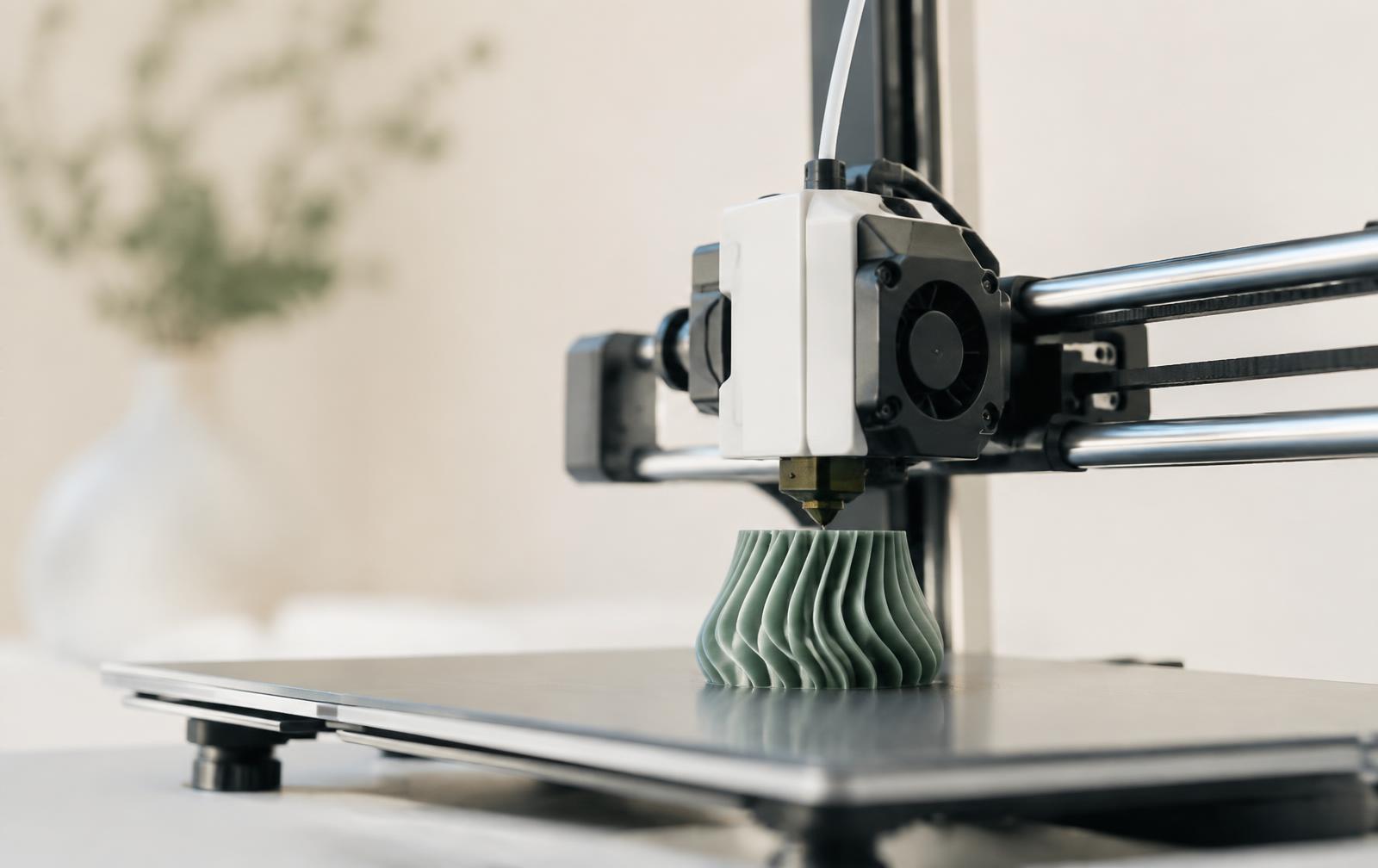 Impressora 3D imprimindo uma peça verde